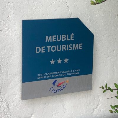 Panonceau Meublé de tourisme 3 étoiles Plaque en aluminium avec pan coupé sur angle supérieur droit. protection anti UV contrecollé, Fixation sur picots à l'arrière de la plaque, aucune fixation apparente. Panonceau de classement hôtelière conforme aux normes imposées par Atout France. Livré avec le kit de fixation.